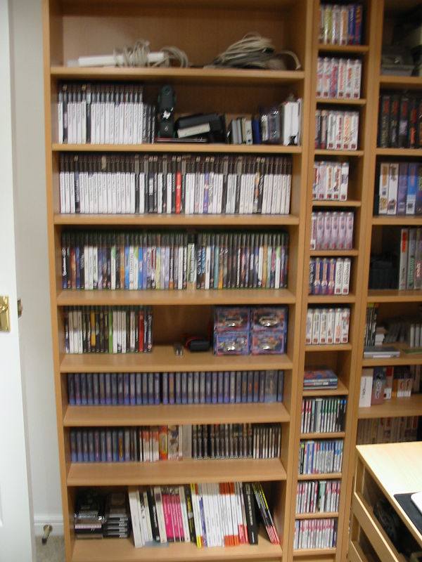 Starting from top down: extensions/cables, region converters &amp; flash/backup devices, Playstation 2 games, XBox 1 games, PAL Dreamcast, NTSC Dreamcast &amp; Saturn, stategy guides &amp; various programming references. Plus a few spare disk drives. Narrow shelving to the right contains a mostly complete PAL NeoGeo Pocket collection and PC-Engine titles further down. The next shelving to the right has Vectrex (original and homebrew), SNES, Gamegear, Master System, Nintendo DS and at the very bottom a shelf a various power adapters.