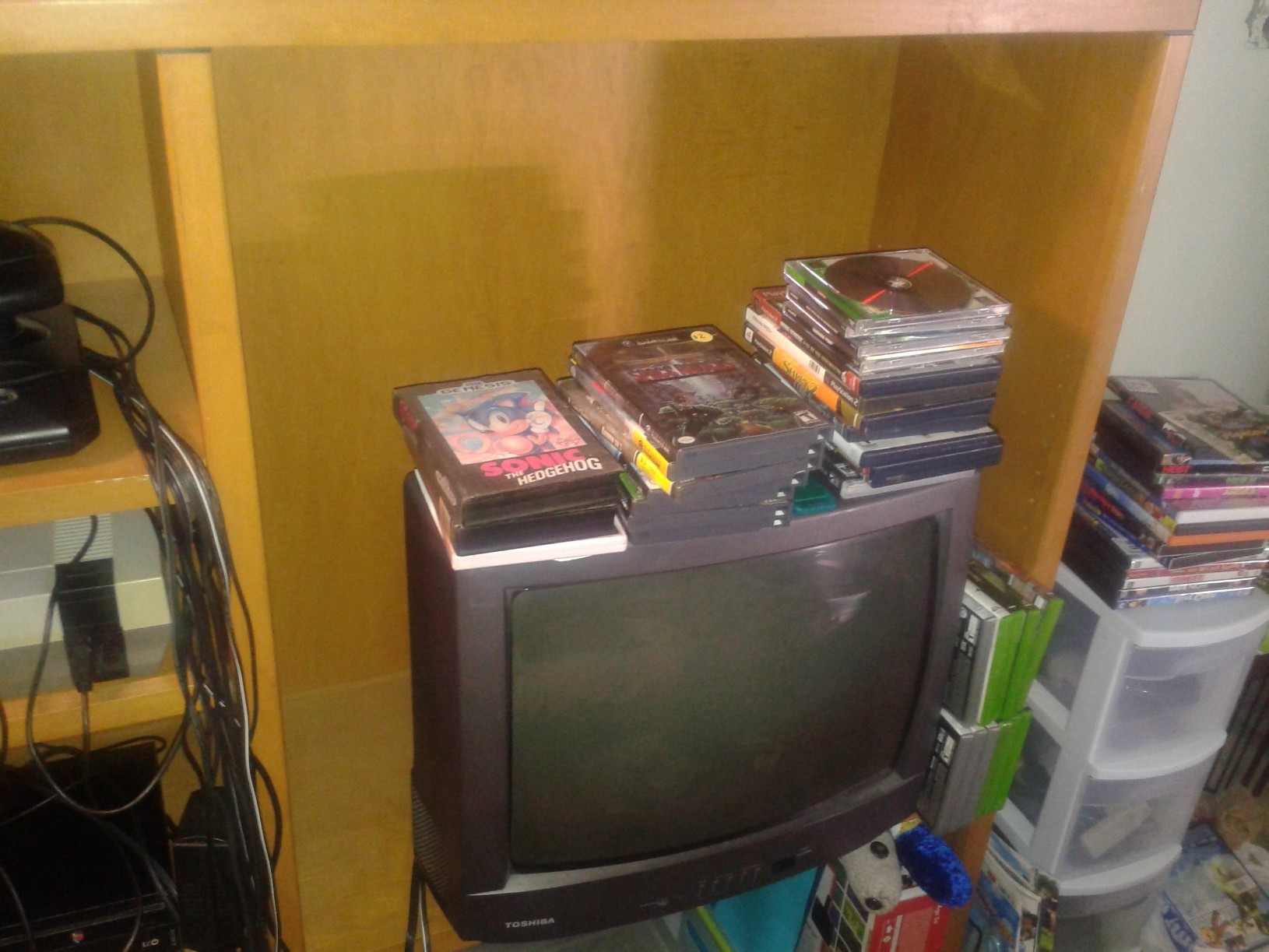 My old TV. The stacks of games on top need to be tested, the plastic thing next to it holds controllers/extra wires. The stack on top of it is DVD's to be tested.